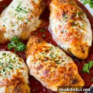 A skillet filled with golden brown baked chicken parmesan, topped with rich marinara sauce and melted cheese.