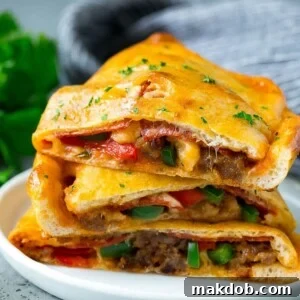 Delicious calzone halves, generously stuffed with savory sausage, crisp peppers, melted cheese, and pepperoni.