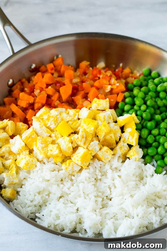 Veggie Fried Rice Recipe | Vegetarian Fried Rice #rice #friedrice #vegetarian #dinner #dinneratthezoo #sidedish Vegetables, scrambled egg, rice and peas in a frying pan, cooking to perfection.