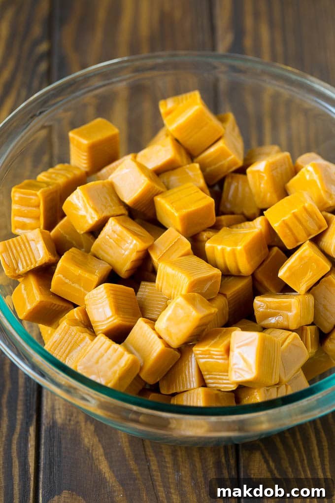 A bowl filled with unwrapped soft caramels, ready to be melted for a rich homemade caramel apple coating.