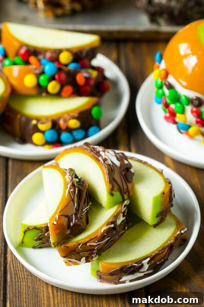 Beautifully prepared and sliced caramel apples on a white plate, showcasing layers of crisp apple, smooth caramel, and chocolate, adorned with various delicious toppings.