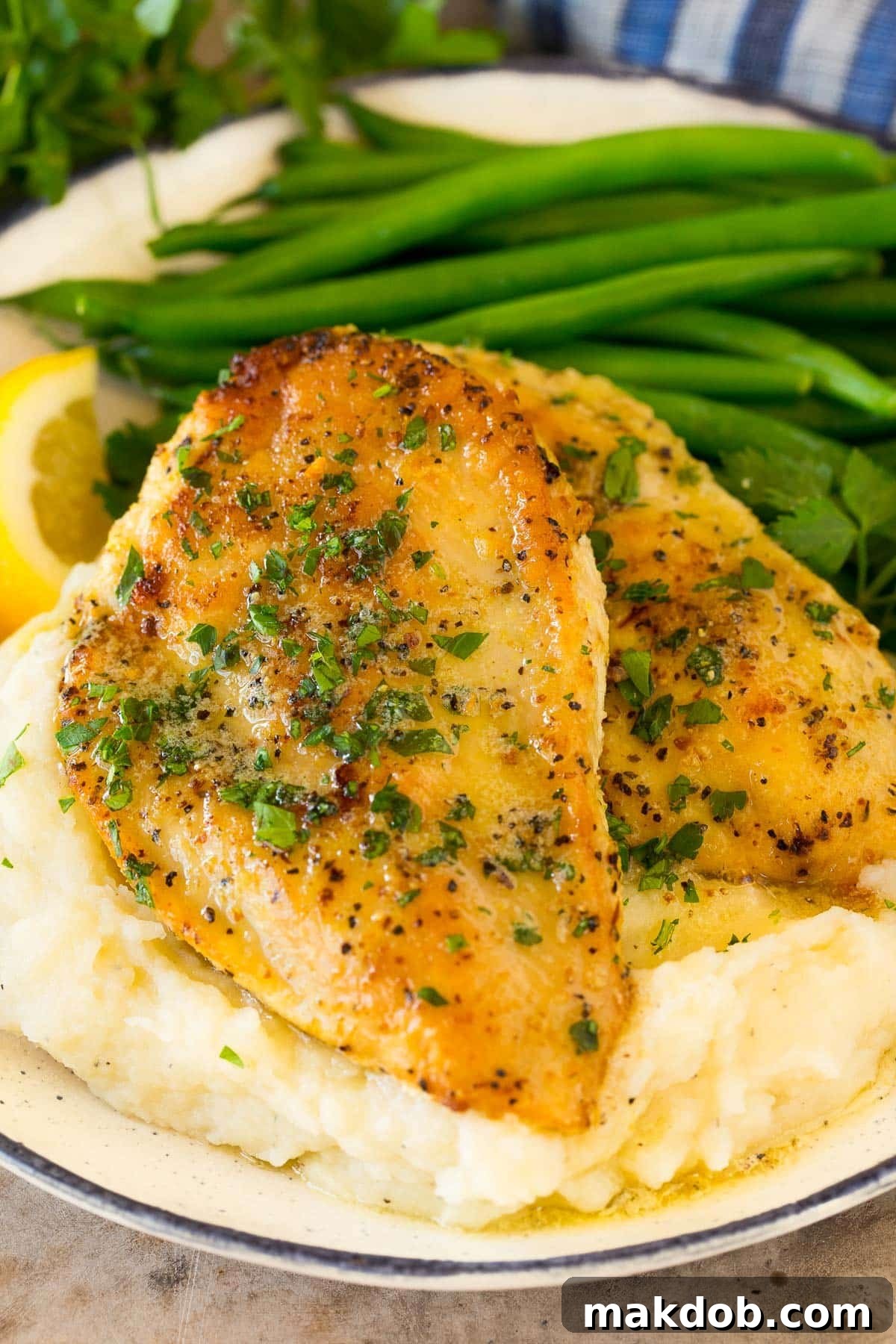 Lemon pepper chicken served with mashed potatoes and green beans.