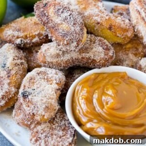 A inviting platter of cinnamon sugar-coated apple fries, golden brown and perfectly crisp, served alongside a rich, decadent caramel dip.