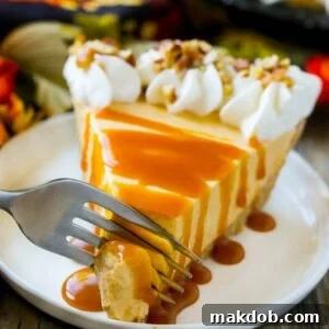 A fork gracefully cutting into a slice of no-bake pumpkin cheesecake, revealing its smooth, creamy texture and enticing layers.