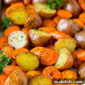 A vibrant medley of roasted potatoes and carrots, infused with aromatic garlic and fresh herbs, baked until tender and golden brown.
