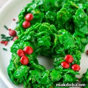 This recipe for no-bake Christmas wreath cookies features just six ingredients and is ready in 15 minutes. These vibrant cornflake wreaths are a delightful and festive addition to any holiday dessert table!