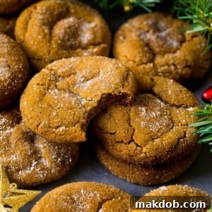 Molasses cookies beautifully coated in sugar, surrounded by festive holiday decorations.