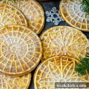 Pizzelle cookies, cooked to a perfect golden brown and delicately coated in powdered sugar.