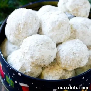 Snowball cookies, delicately coated in powdered sugar and elegantly served in a festive holiday tin.