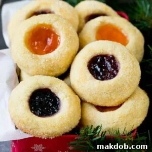 Thumbprint cookies beautifully arranged in a tin, perfect for gift giving during the holidays.