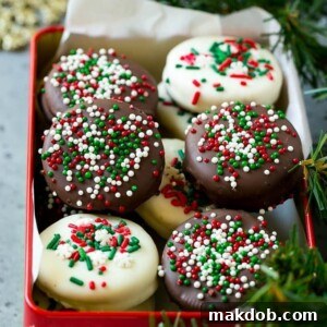 An image of chocolate covered Oreo cookies in a red gift box, beautifully decorated with colorful sprinkles.
