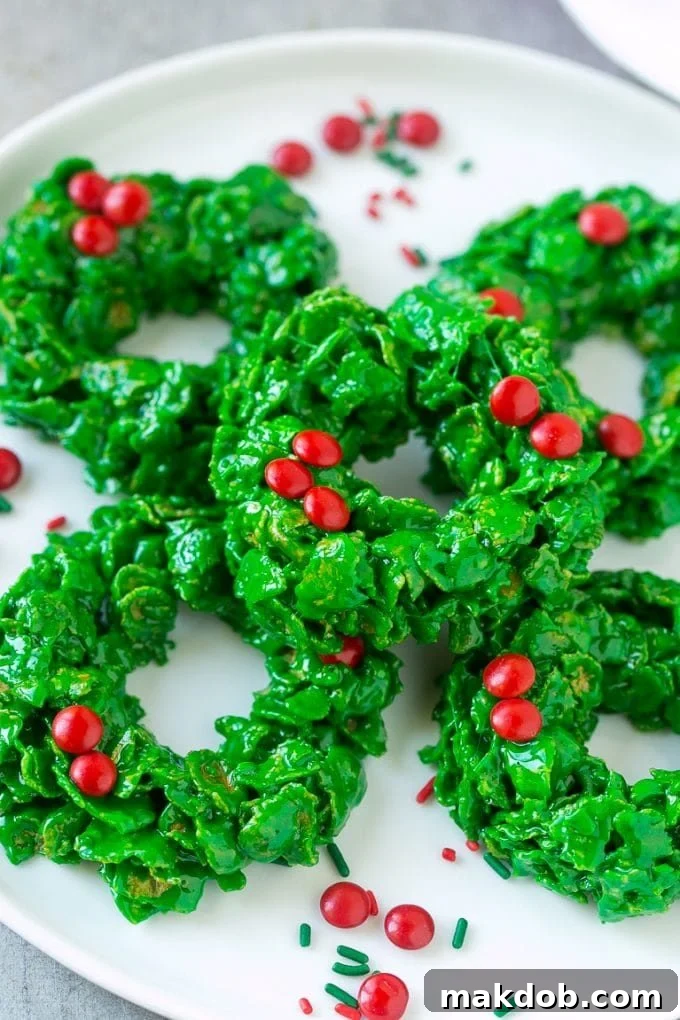 Christmas Wreath Cookies Recipe | Cornflake Wreaths | Cornflake Cookies | No Bake Cookie Recipe #cookies #wreath #christmas #holiday #nobake #dessert #dinneratthezoo A beautifully arranged plate of bright green cornflake wreath cookies, adorned with red candy, a classic holiday treat.