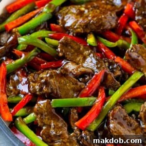 Pepper steak stir fry with thinly sliced steak and red and green bell peppers in a savory sauce.