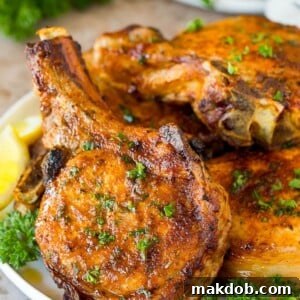 A plate of air fryer pork chops garnished with parsley.