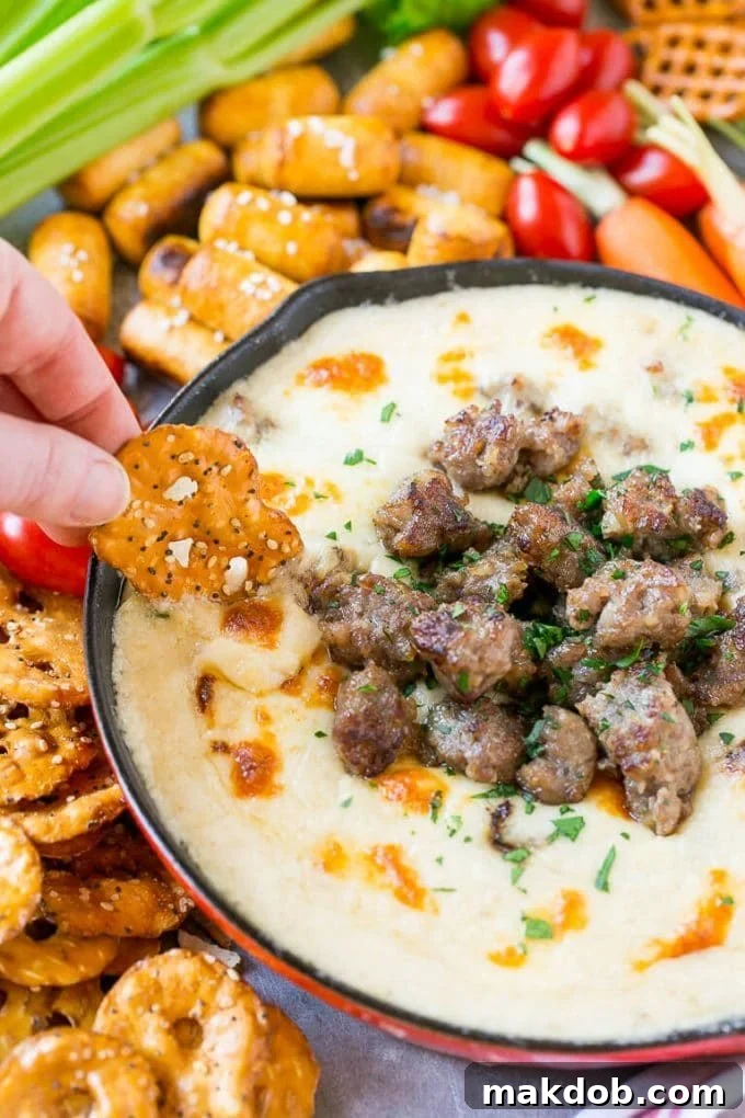 Brat & Beer Cheese Dip Recipe | Beer Cheese Dip | Cheese Dip | Easy Appetizer #beer #cheese #dip #sausage #appetizer #dinneratthezoo A pretzel chip scooping up some beer cheese dip.