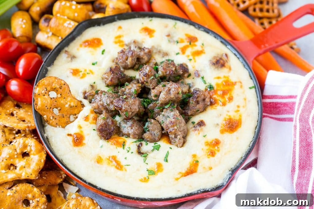 Brat & Beer Cheese Dip Recipe | Beer Cheese Dip | Cheese Dip | Easy Appetizer #beer #cheese #dip #sausage #appetizer #dinneratthezoo Beer cheese dip in a red skillet topped with cooked crumbled bratwurst sausage.