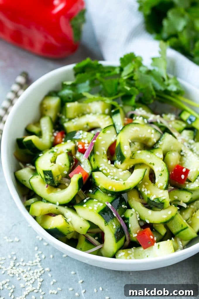 This recipe for Asian cucumber salad features crisp cucumbers and colorful vegetables coated in a vibrant sesame dressing. It's an effortlessly quick and healthy side dish, perfect for any occasion.