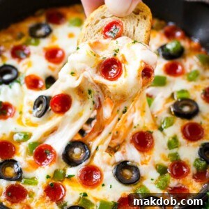 Pizza dip is loaded with all your favorite pizza toppings, baked to golden and gooey perfection and served with baguette slices.