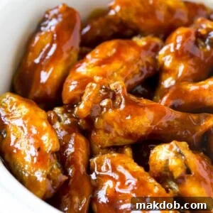A slow cooker full of barbecue chicken wings, tender and coated in savory sauce.