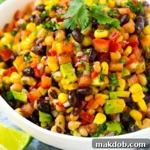 A serving bowl of cowboy caviar made with beans and veggies, and garnished with cilantro.