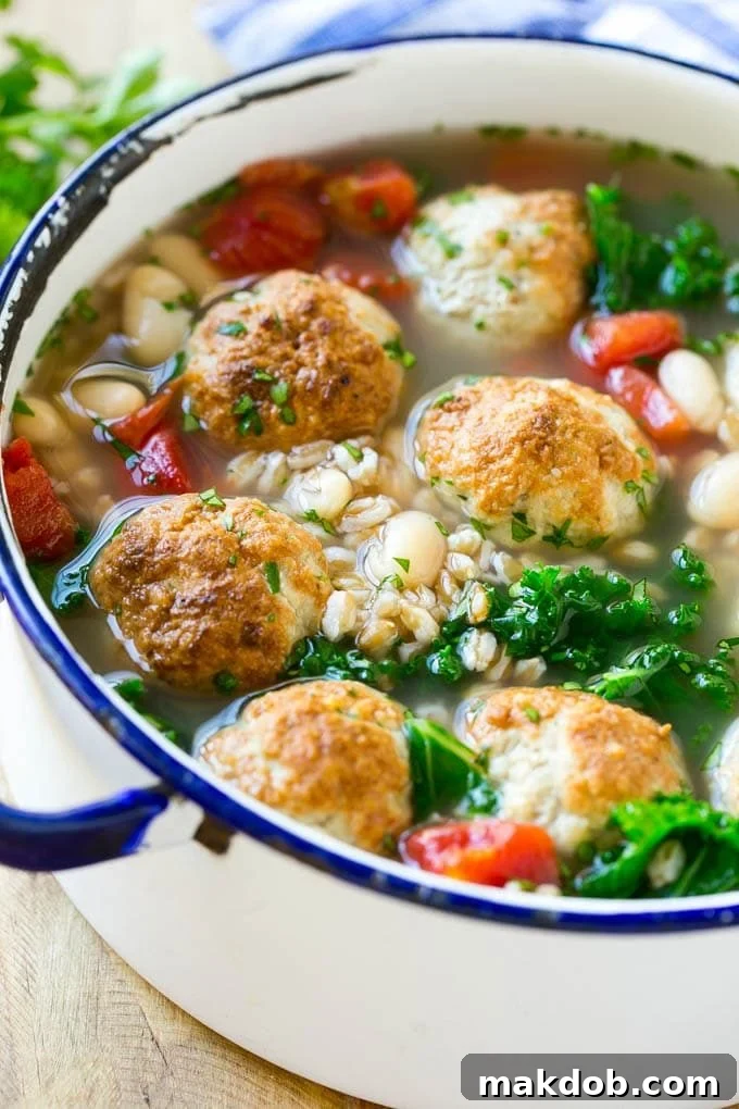A vibrant bowl of Farro Soup with tender turkey meatballs, creamy white beans, and fresh kale, perfect for a healthy and hearty meal.
