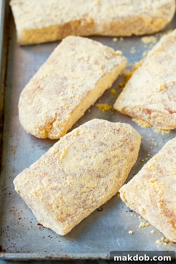 Breaded fish fillets on a sheet pan, ready for cooking to become crispy Baja fish tacos.