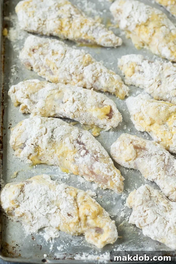 Perfectly Breaded Chicken Tenders Before Frying Crispy breaded chicken fingers ready for deep frying.