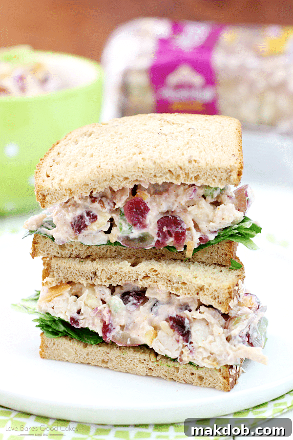 Lighter Chicken Salad Sandwiches served on whole wheat bread, garnished with fresh herbs.