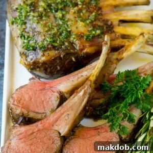 A platter of rack of lamb garnished with fresh herbs.