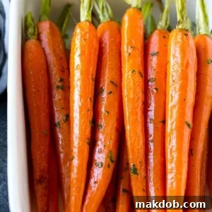 Honey roasted carrots in a baking dish, garnished with chopped parsley.