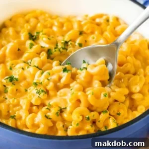 A pot of stovetop mac and cheese with a serving spoon in it.
