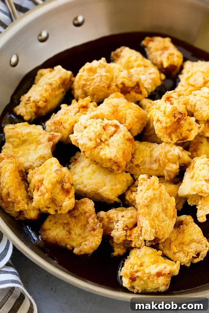 Sesame Chicken Recipe | Crispy Chicken | Asian Chicken #sesame #chicken #asian #dinner #dinneratthezoo Crispy chicken in a pan with sesame sauce, being tossed, showing the rich coating.