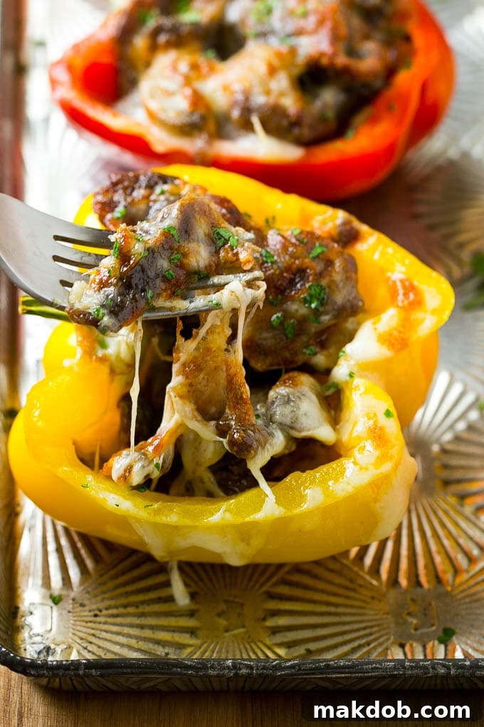 A fork pulling some steak out of a stuffed pepper.