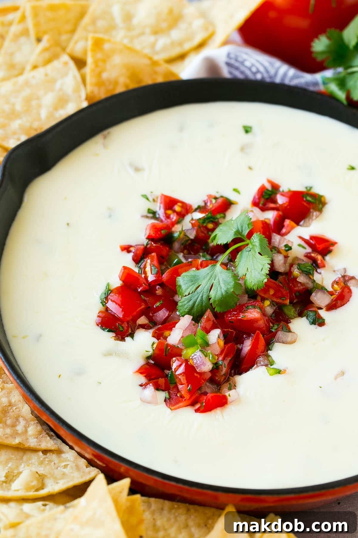 Velvety Queso Blanco 5 A pan of queso dip topped with pico de gallo.