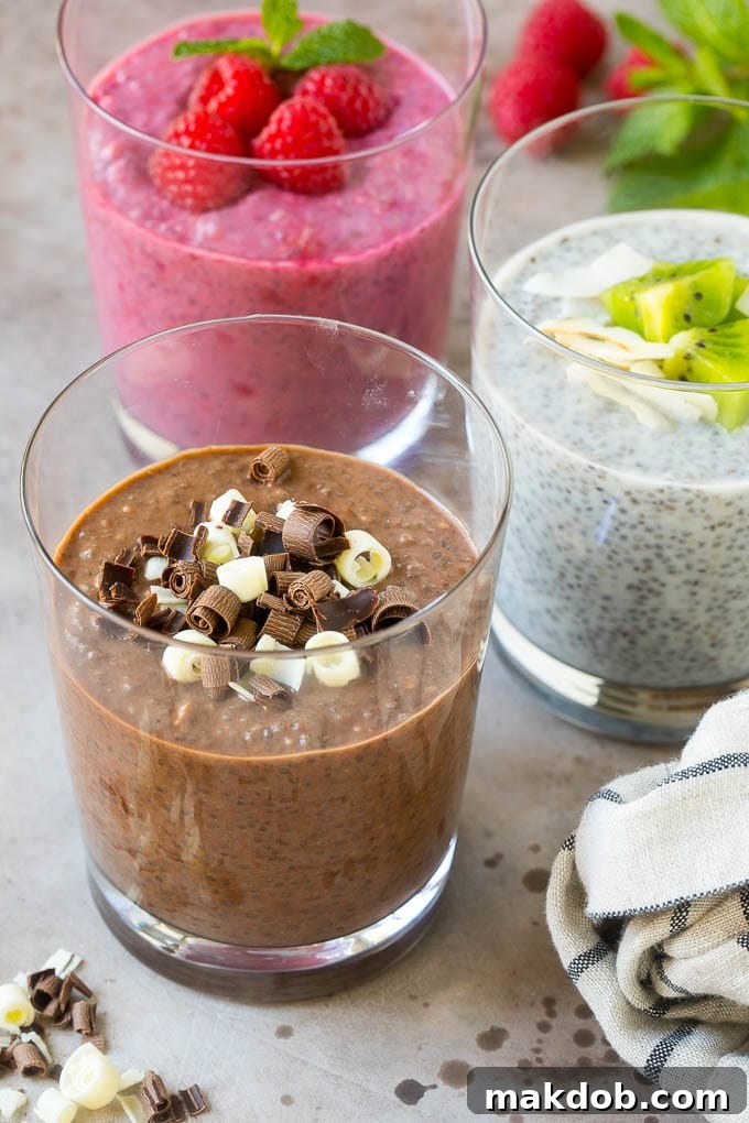 Three cups of chia pudding topped with chocolate and fruit, then garnished with mint.