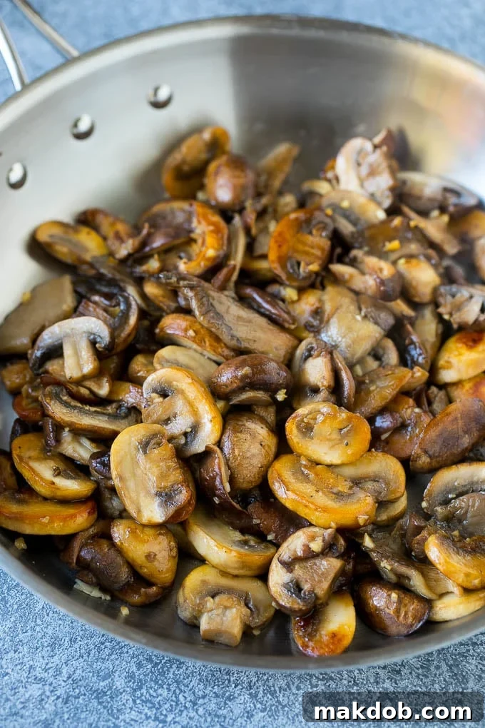 An assortment of sauteed mushrooms in a skillet.