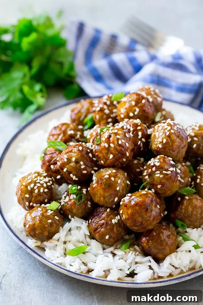 Delicious & Quick Teriyaki Meatballs Recipe | Easy Asian Beef Meatballs for Dinner or Appetizers #teriyakimeatballs #easydinner #asianfood #meatballrecipe Perfectly glazed teriyaki meatballs served over a bed of fluffy steamed rice, garnished with toasted sesame seeds and fresh green onions for a vibrant, flavorful meal.