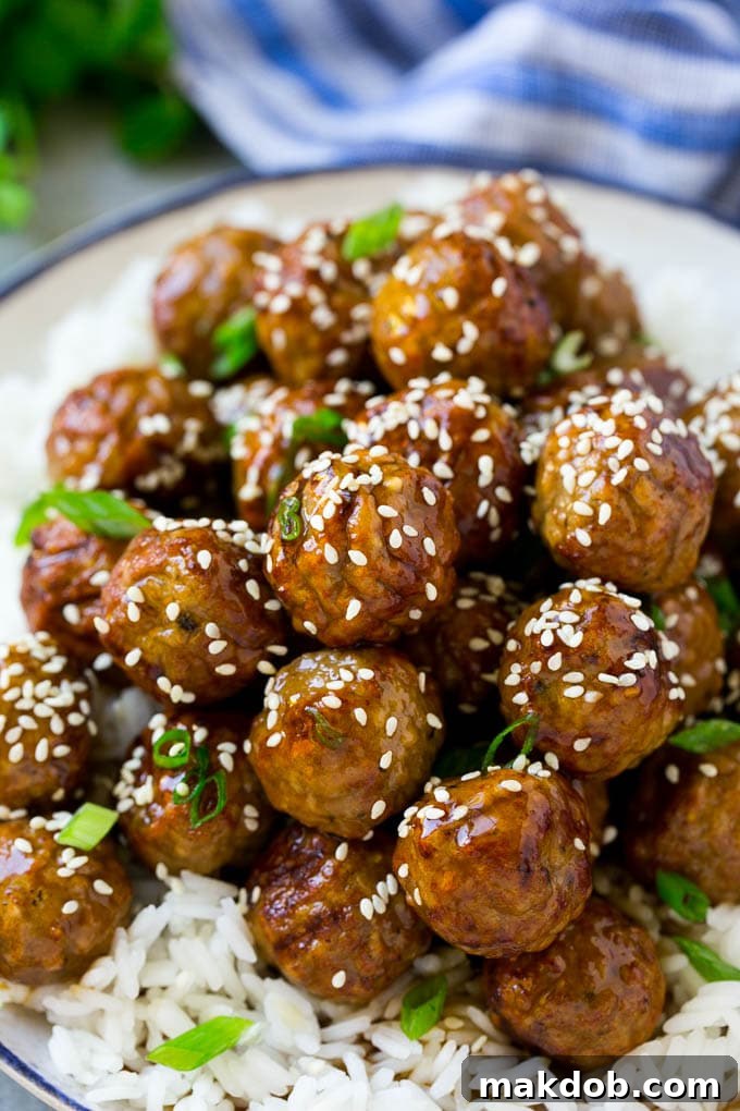 Gourmet Teriyaki Meatballs with Savory Sauce and Fresh Garnish Juicy meatballs glistening with homemade teriyaki sauce, generously topped with sesame seeds and fresh green onions, ready to be enjoyed.