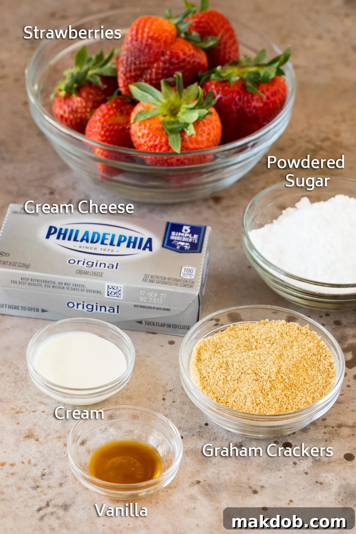 Strawberry Cheesecake Delights 3 Ingredients for cheesecake stuffed strawberries including fresh strawberries, cream cheese, powdered sugar, and graham cracker crumbs on a wooden surface.