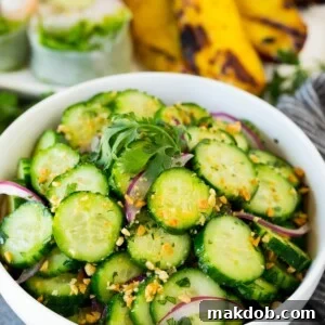 A bowl of Thai cucumber salad topped with peanuts and cilantro.