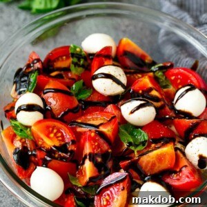 Caprese salad with tomatoes, fresh mozzarella, basil leaves and balsamic glaze.