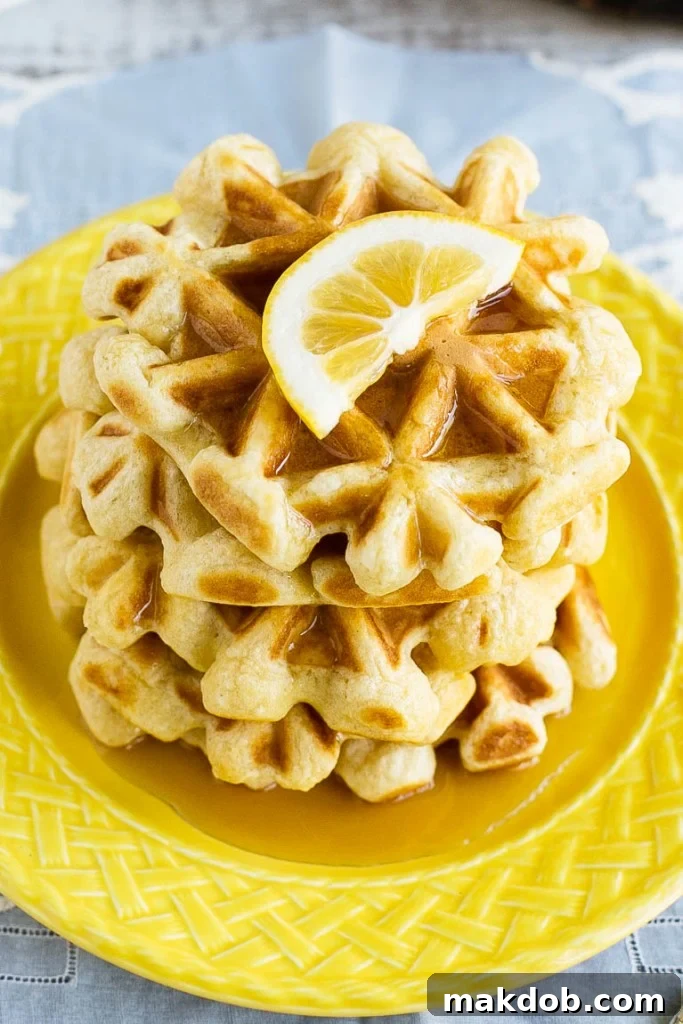 Zesty Lemon Sour Cream Waffles 2 Fluffy lemon sour cream waffles, stacked high and drizzled with maple syrup, perfect for a vibrant weekend breakfast or brunch. Discover the secret to light and airy waffles with a zesty kick.