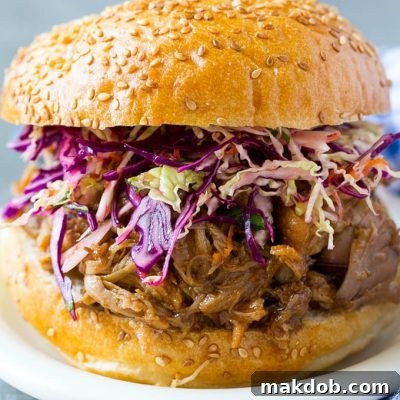 Tender Slow-Cooked BBQ Pork Sandwiches 2 A pulled pork sandwich topped with slaw.