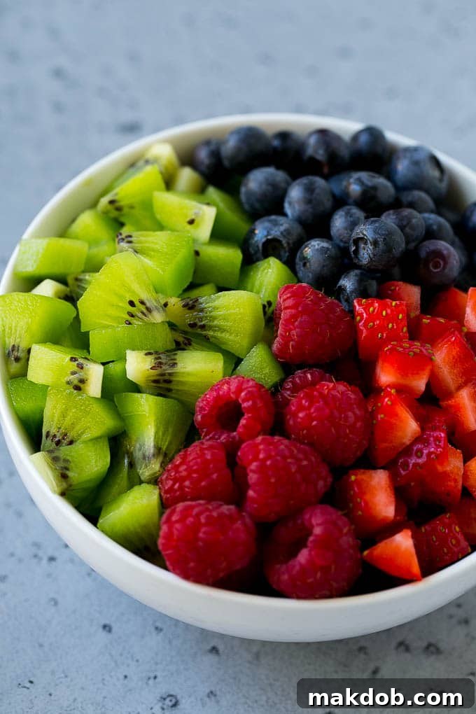 A bowl of raspberries, kiwi, strawberries and blueberries.