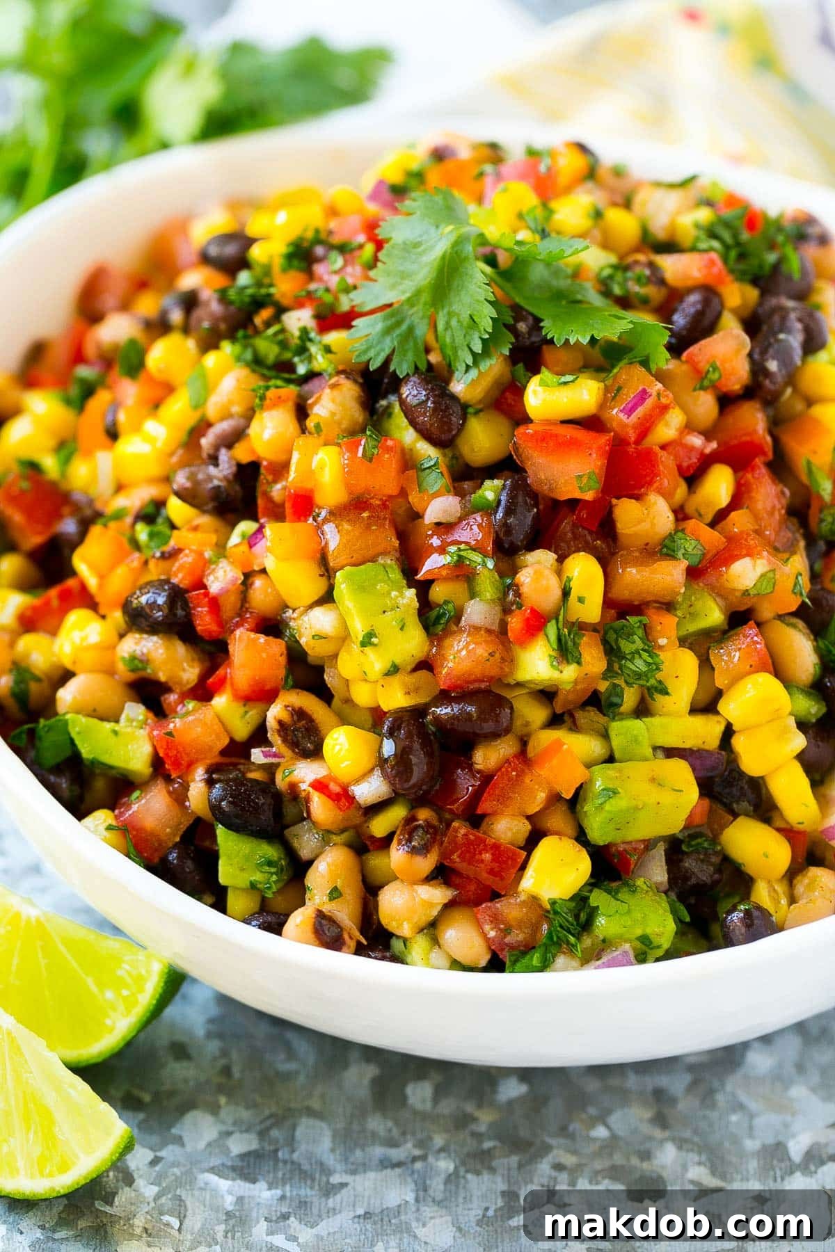 Fiesta Bean Salad 2 A serving bowl of cowboy caviar made with beans and veggies, and garnished with cilantro.