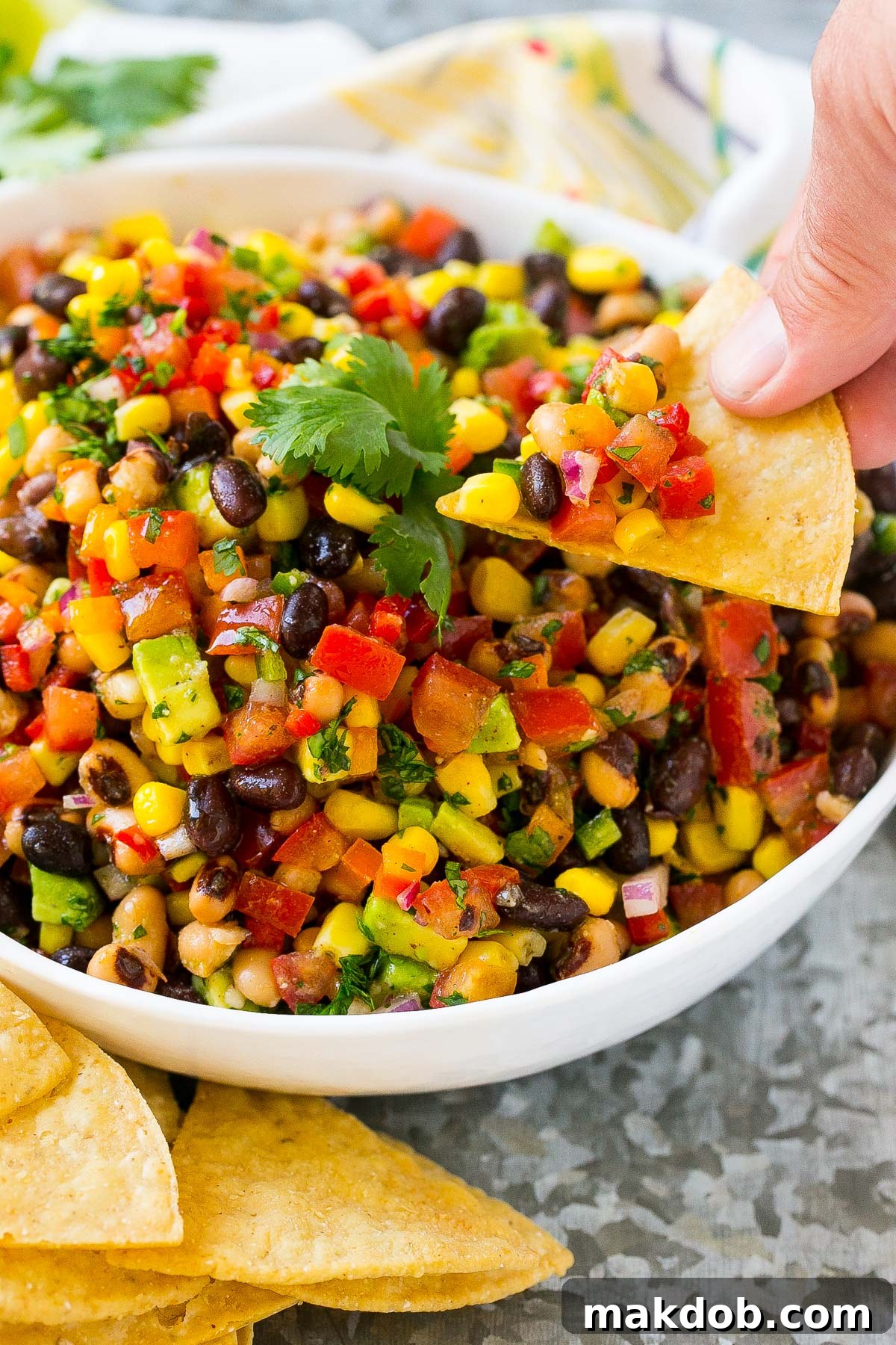 Fiesta Bean Salad 6 A hand scooping up Texas caviar on a chip.