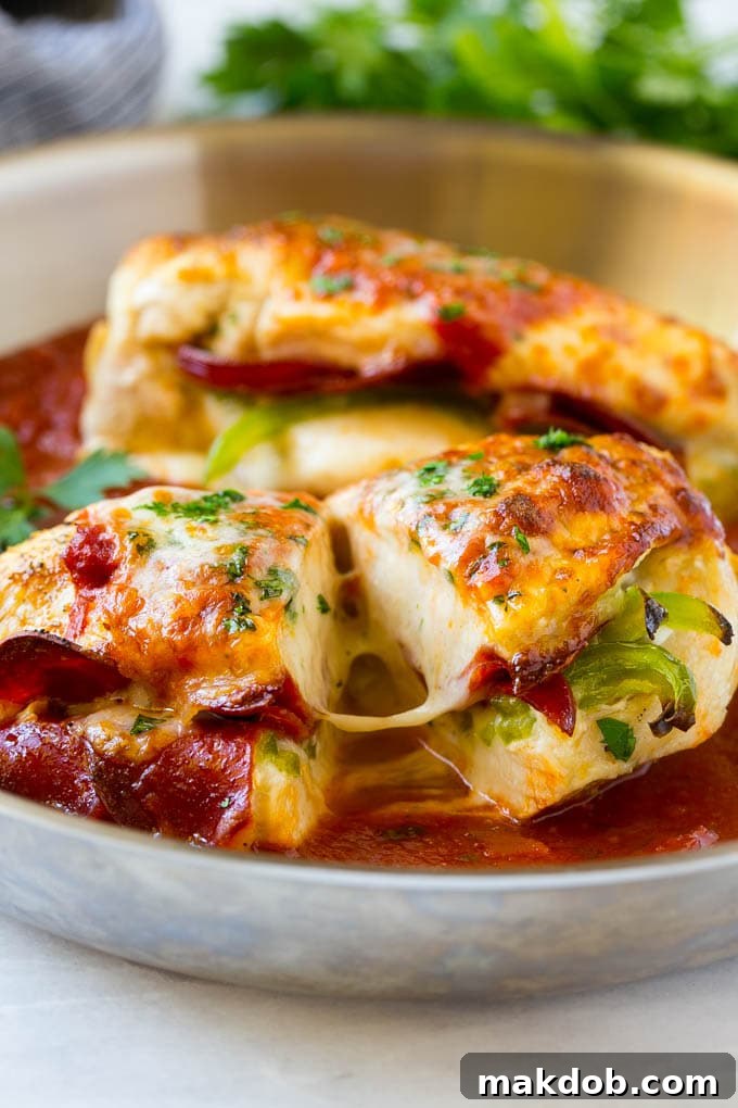 Pizza Stuffed Chicken Recipe | Stuffed Chicken Breast | Baked Chicken Breast | Easy Chicken Recipe #chicken #pizza #stuffedchicken #chickenbreast #dinner #dinneratthezoo A perfectly cooked pizza stuffed chicken breast, sliced in half to reveal the molten pepperoni and cheese filling, in a pan of marinara sauce.