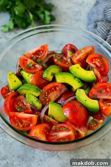 Tomato avocado salad with red onion and a cilantro lime dressing.