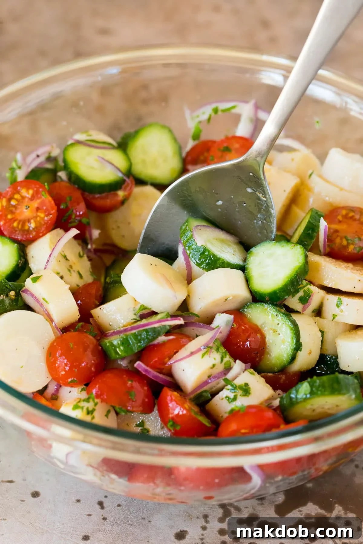 A spoon stirring together a salad.