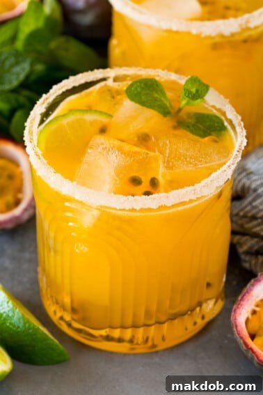 A passion fruit margarita topped with mint, lime and fresh passion fruit.